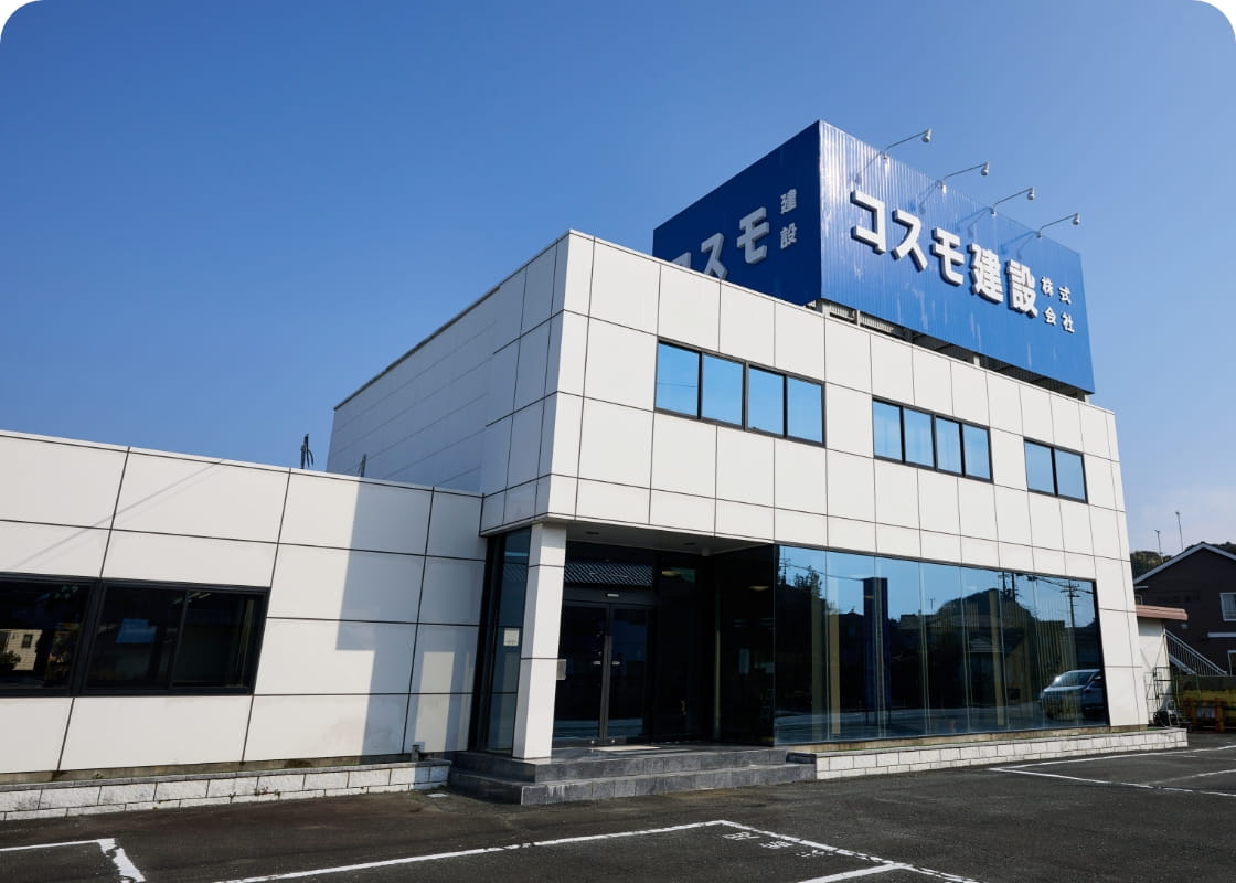 青空の下に建つコスモ建設株式会社の看板