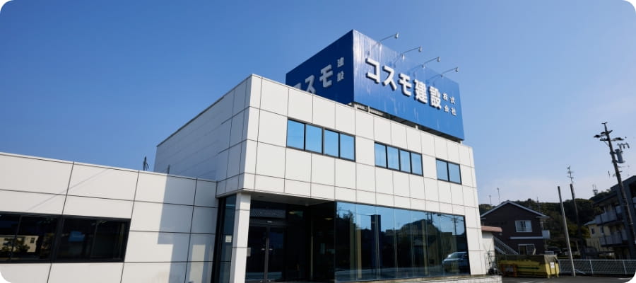 青空の下に建つコスモ建設株式会社の看板
